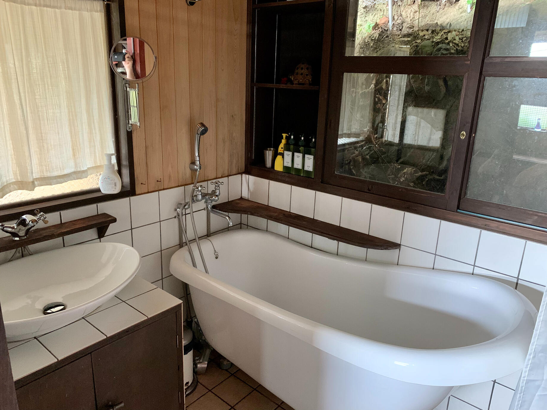 The bathroom has a clawfoot tub with its own private and shaded view.